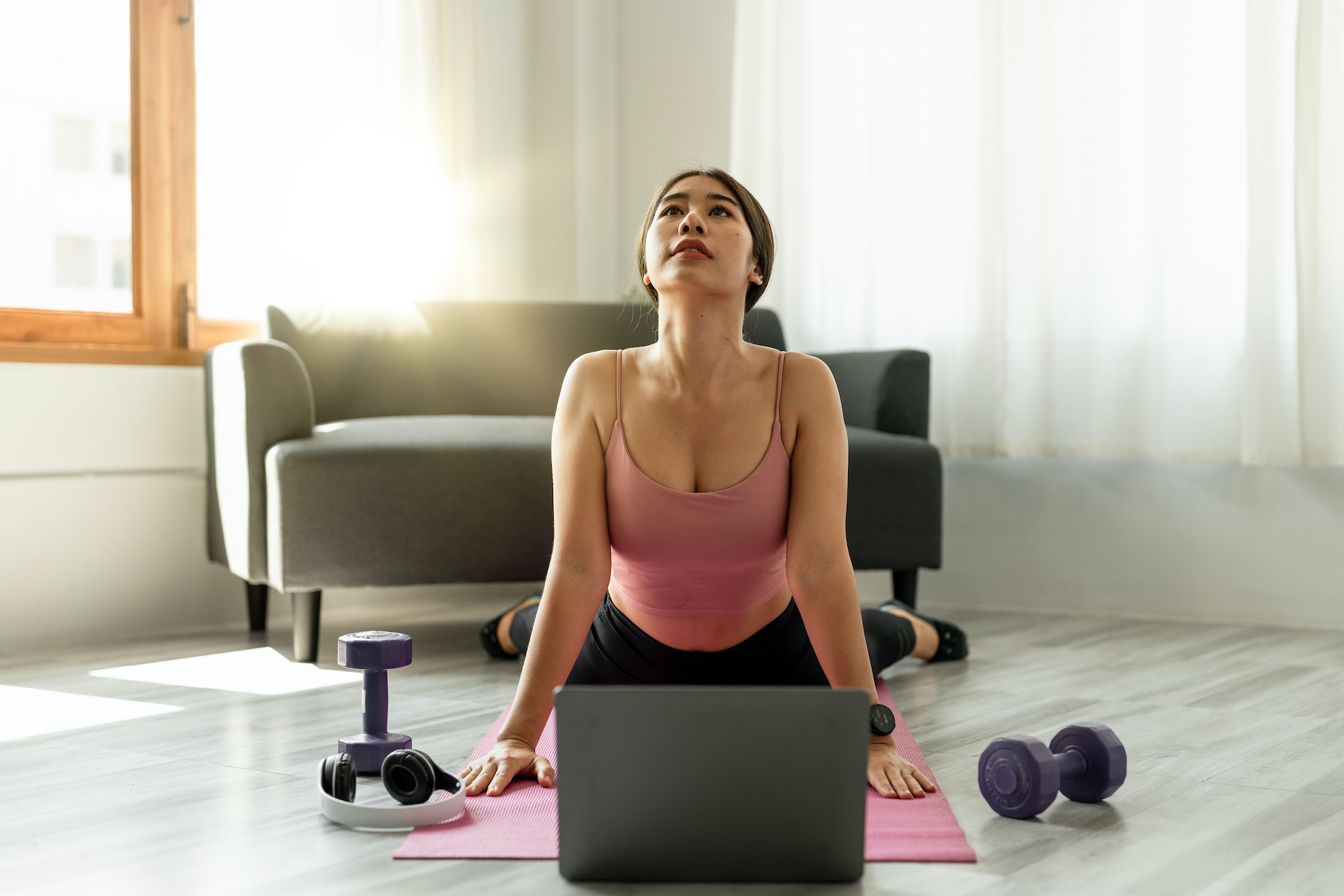 Fitness instructor having virtual yoga class using video call on laptop. Remote yoga teacher leads a Fitness instructor having virtual yoga class using video call on laptop. Remote yoga teacher leads a