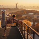 Woman doing yoga on the roof of a skyscraper in big city